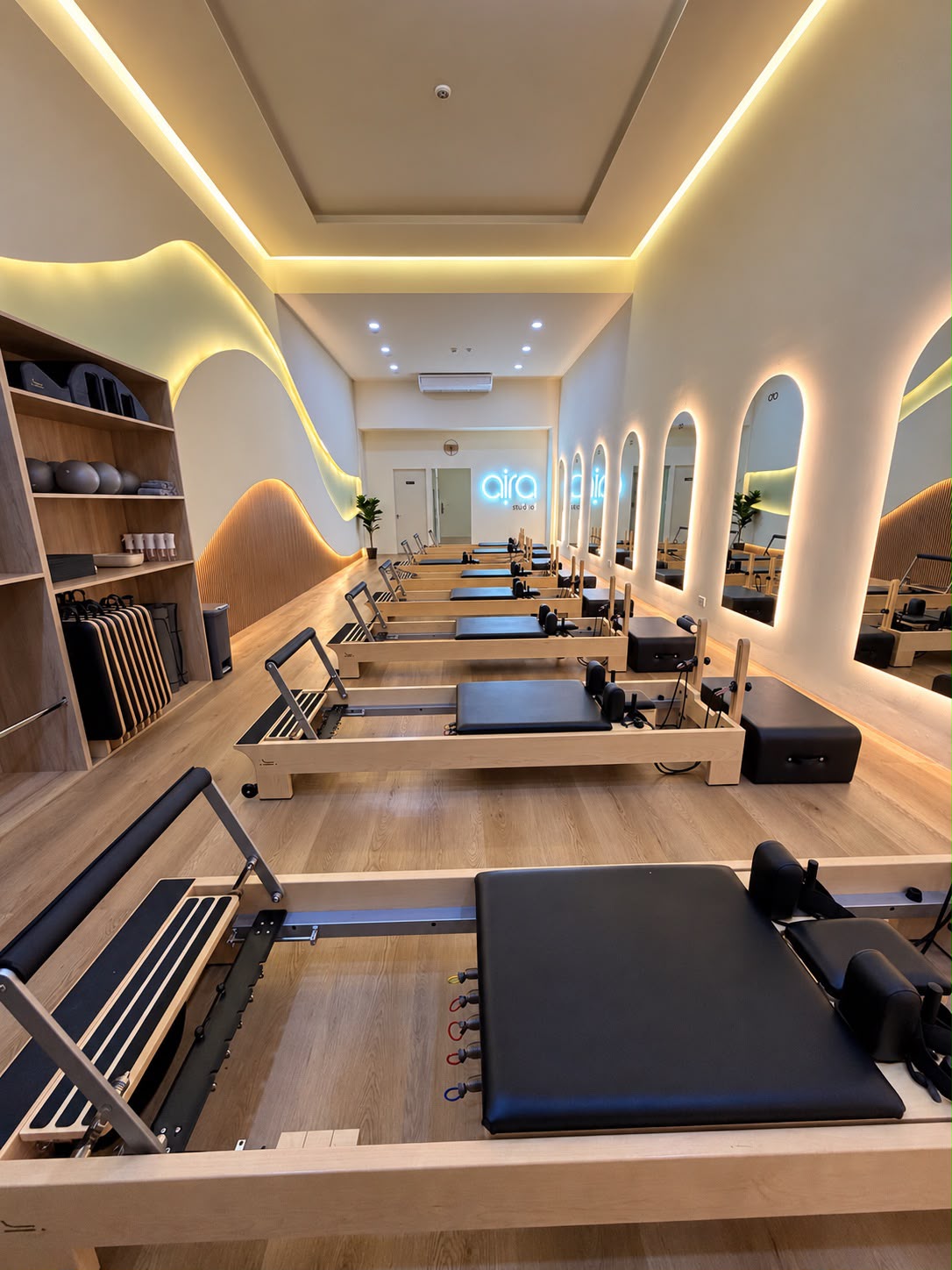 Sala de Aira con máquinas Reformer, luz cálida y espejos en arco